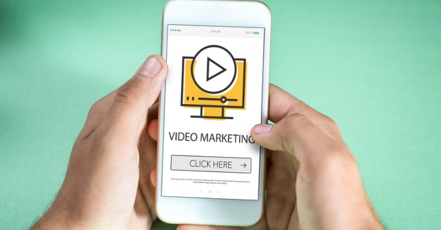 Hands holding smart phone with video landing page shown