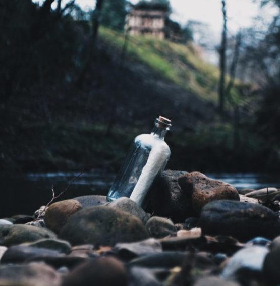 Bottle with message inside in a riverbed